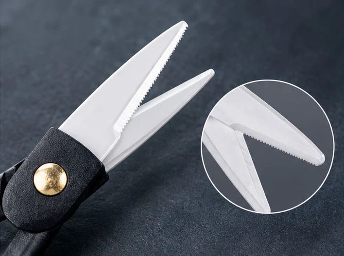 Close-up of zirconia ceramic fishing scissors showing the serrated edge on one blade for fishing line cutting