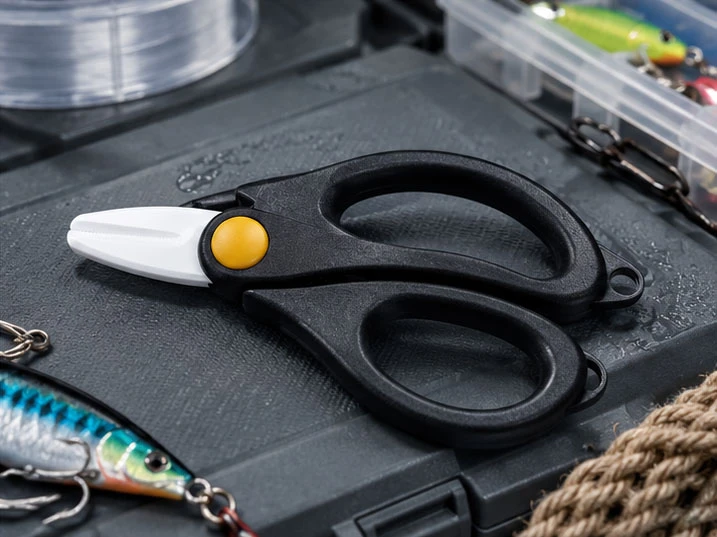 Custom ceramic fishing scissors displayed with fishing tackle and accessories